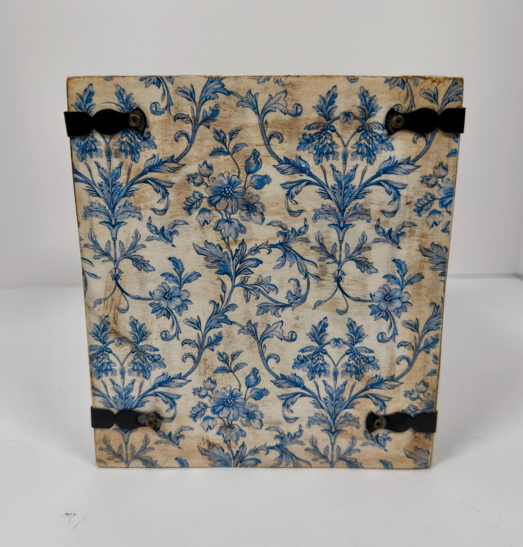 a square-shaped object with a blue floral pattern on its surface.