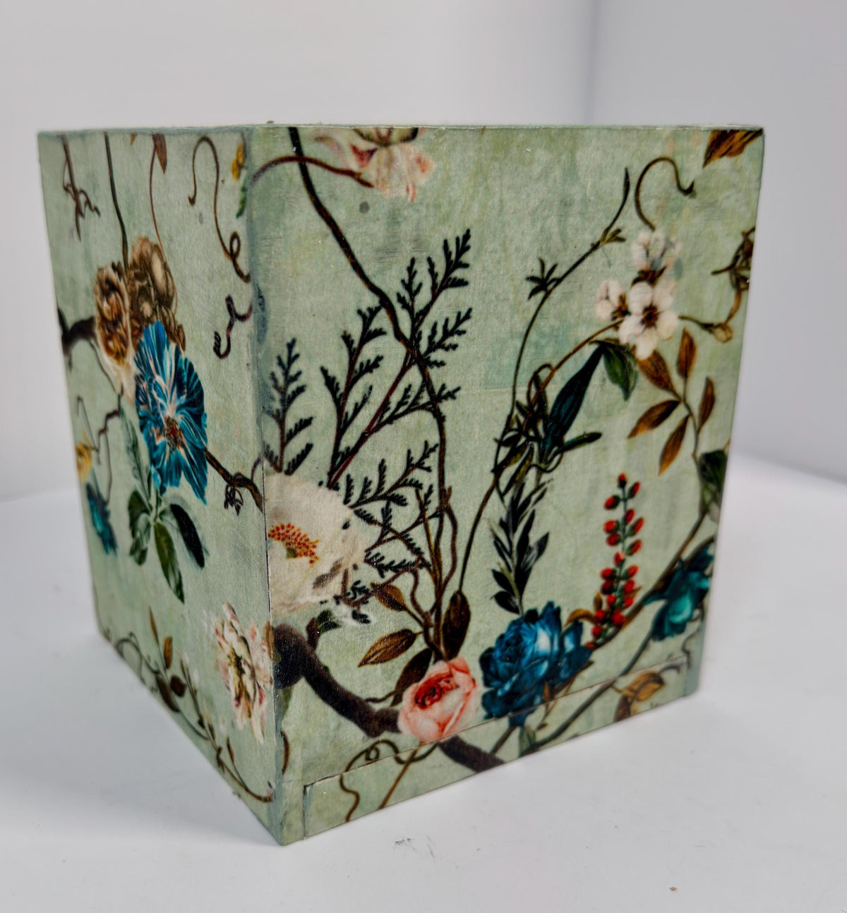 a square-shaped object with a floral pattern on it, which appears to be a decorative piece.