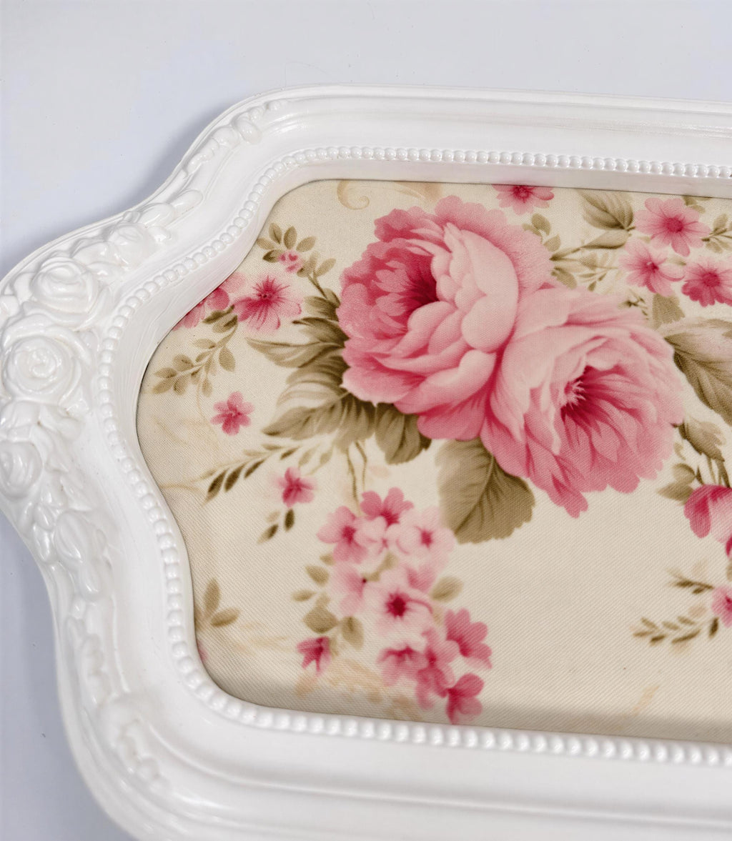A white decorative tray with a floral pattern on the surface.