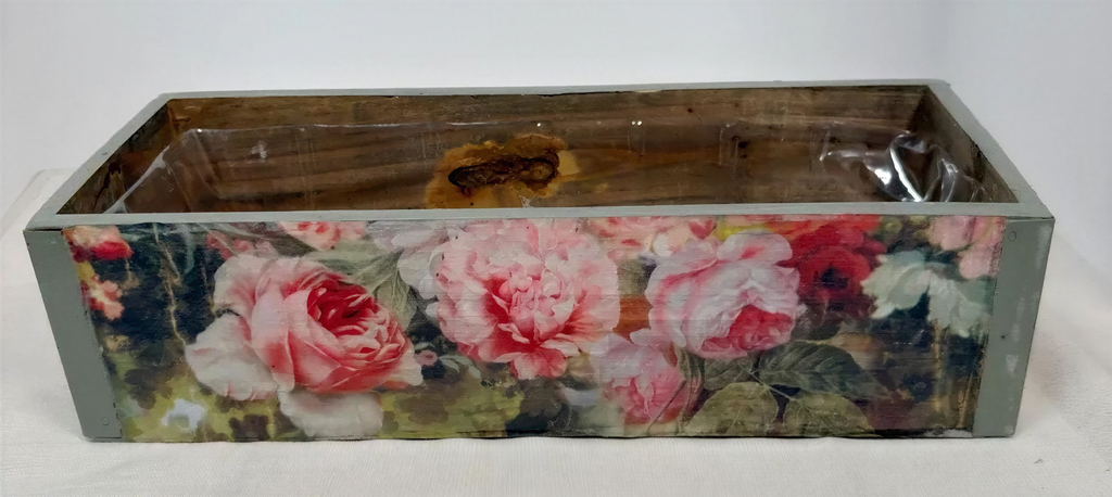 A wooden box with a floral pattern on its side, featuring pink and red roses.