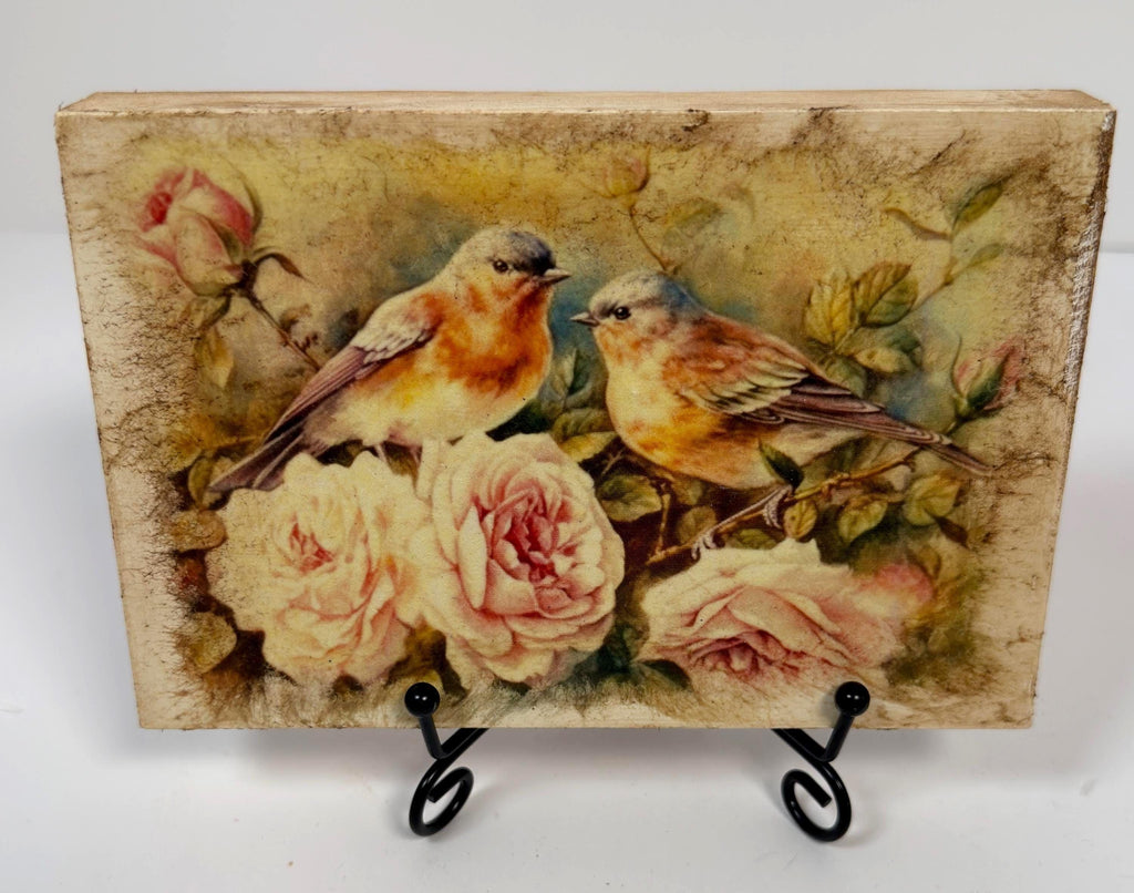 a painting of two birds perched on branches with pink roses in the background.