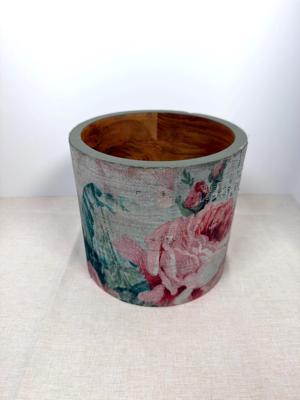 a cylindrical object with a floral pattern on it, placed on a light-colored surface.