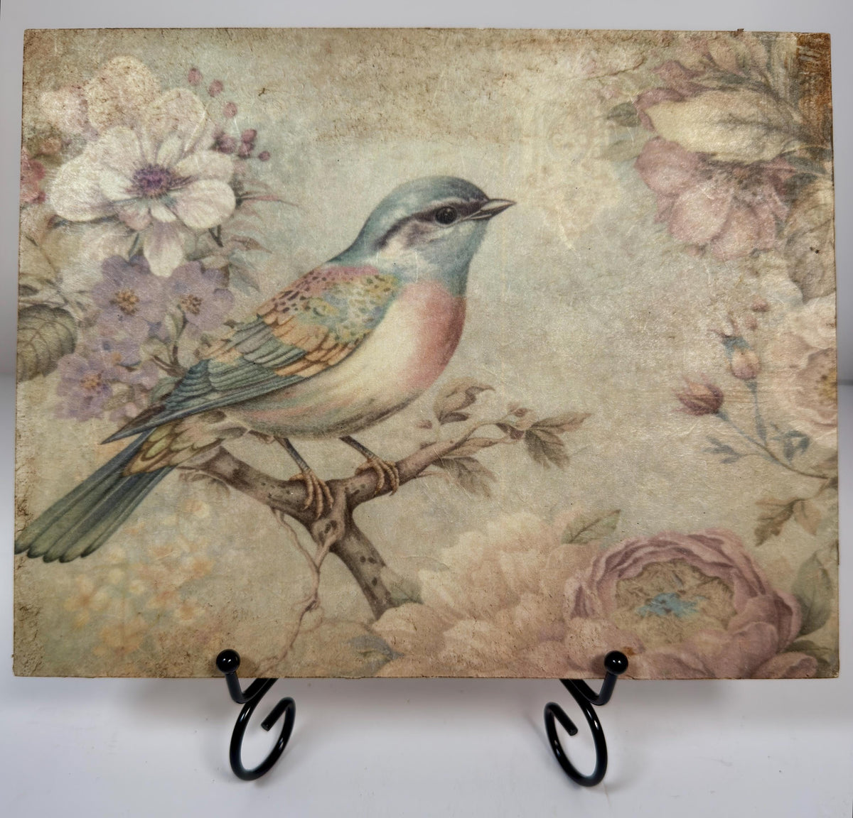 a painting of a colorful bird perched on a branch, surrounded by flowers and foliage.
