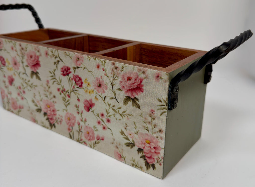 A wooden box with a floral pattern on its side, featuring three compartments.