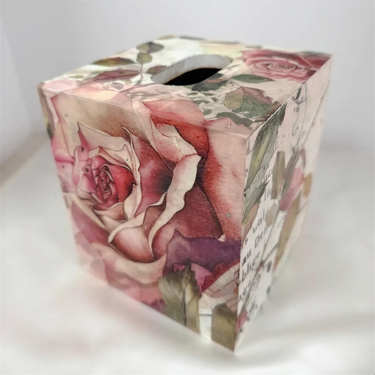 A decorative box cover with a floral pattern featuring roses and other flowers.