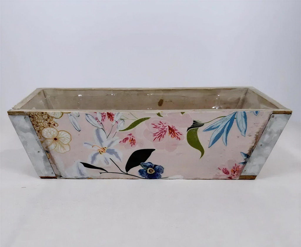 A rectangular planter with a floral pattern on its side, sitting on a white surface.