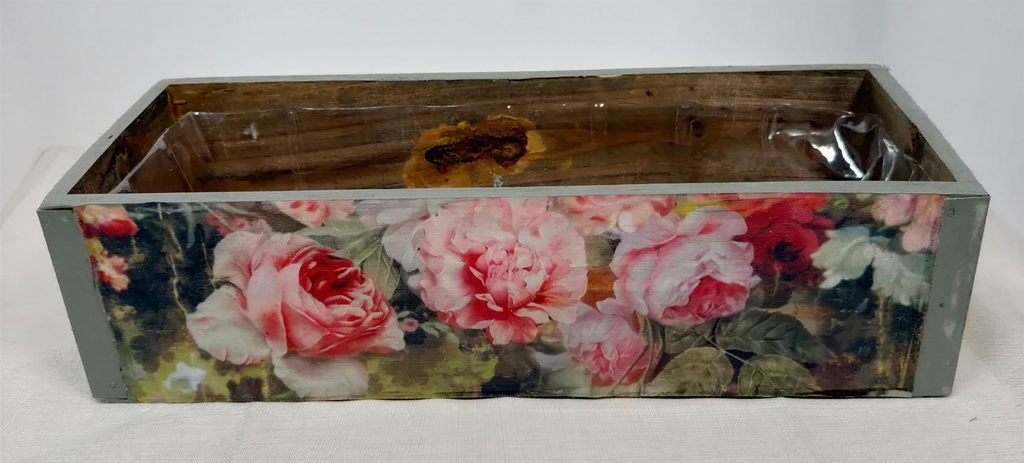 a wooden box with a floral design on its side, including pink and red roses.