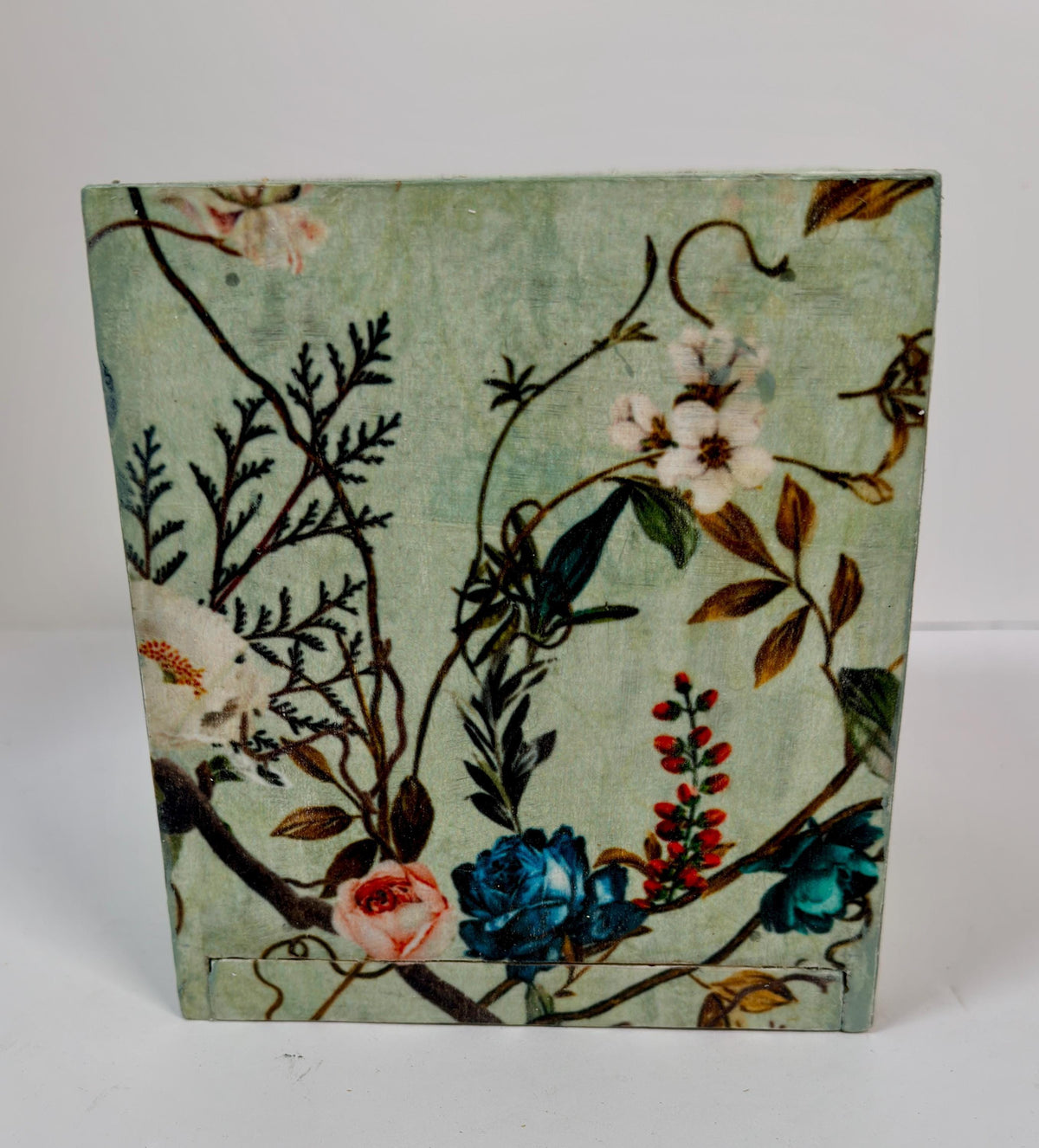 a wooden box with a floral pattern on its surface.