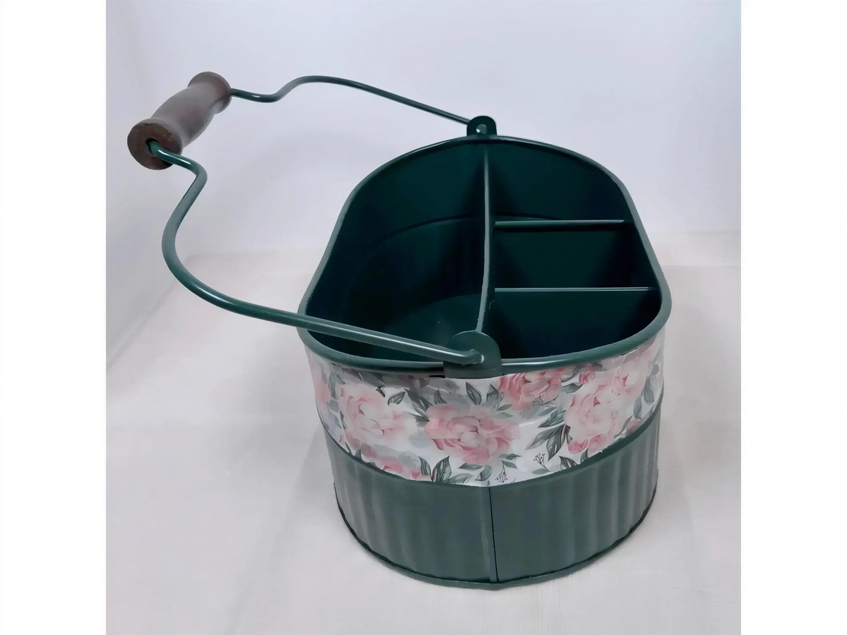 A green metal bucket with a floral pattern on the side, featuring a handle and a curved top.