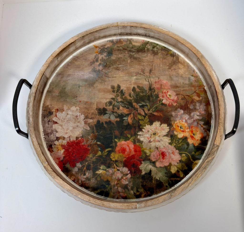 a round wooden tray with a floral design on it.