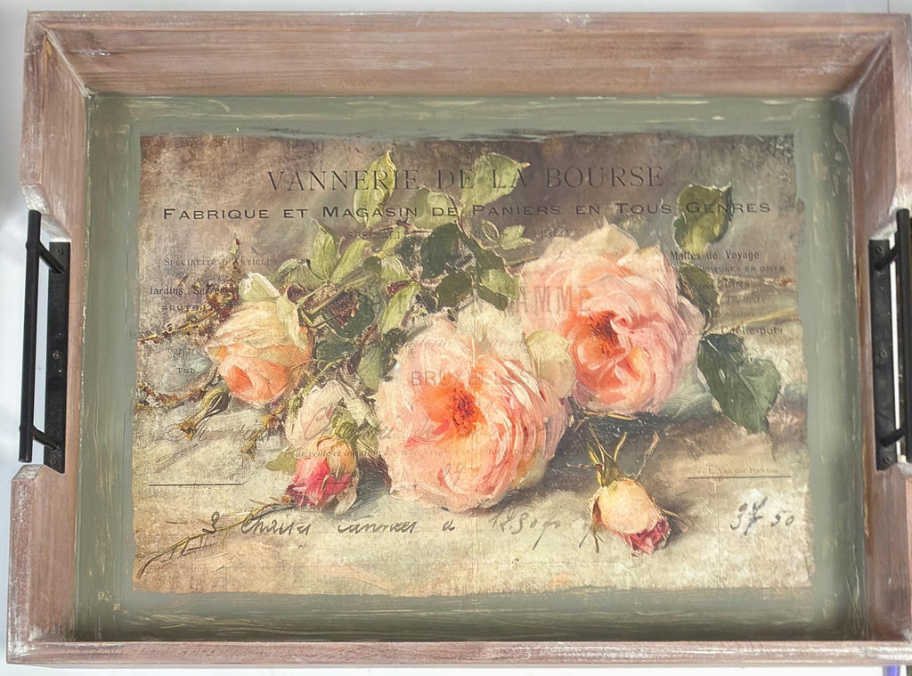 The image is a framed painting of a bouquet of pink roses on a wooden tray.