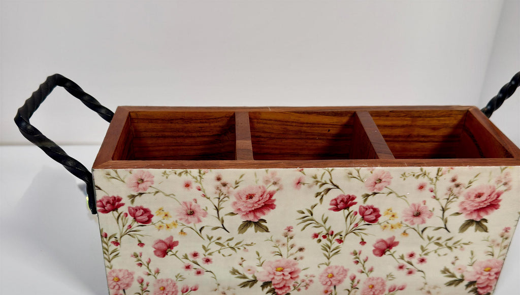 A wooden box with a floral pattern on it, featuring three compartments.