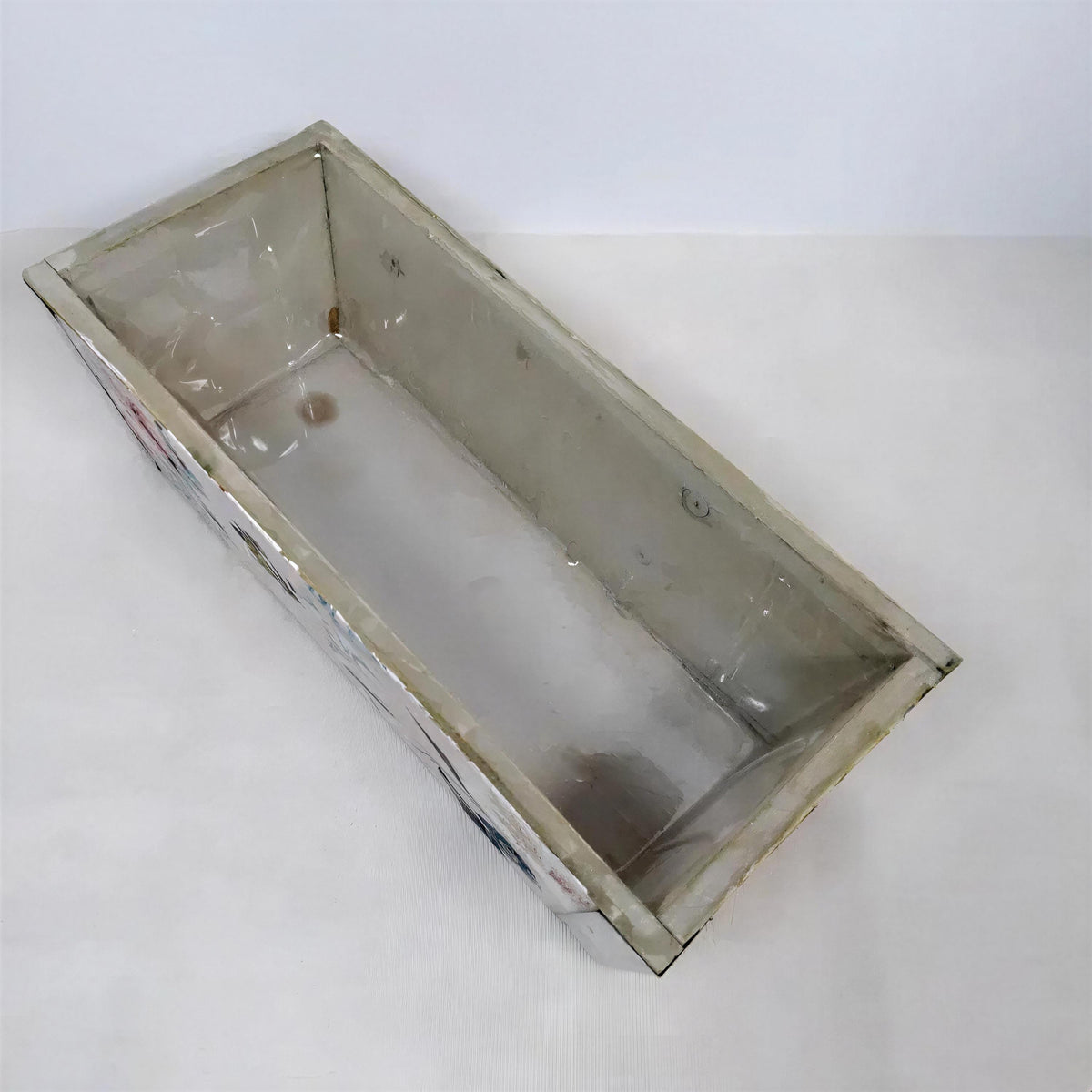 a rectangular, empty metal container with a white interior.