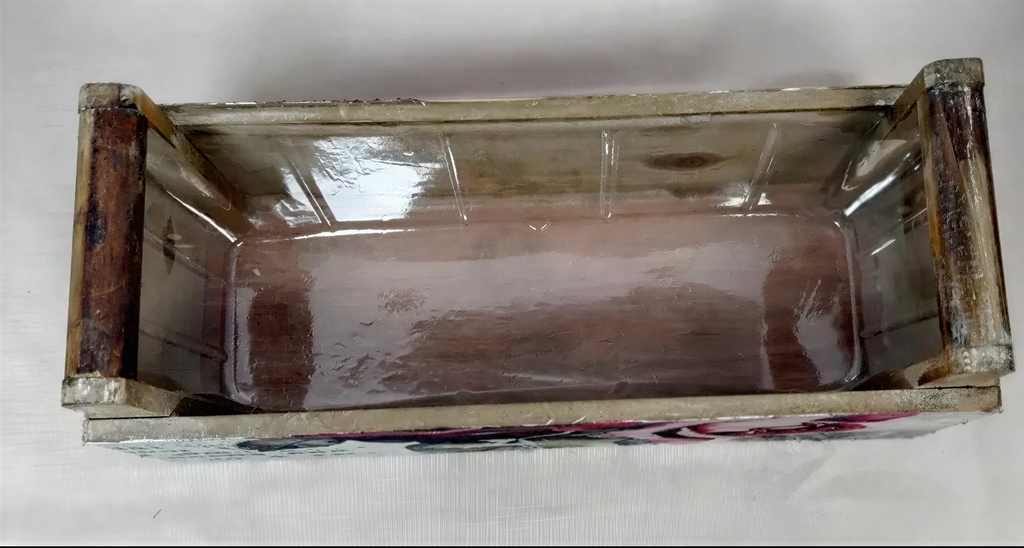 a wooden crate or box with a clear plastic window, sitting on a white surface.