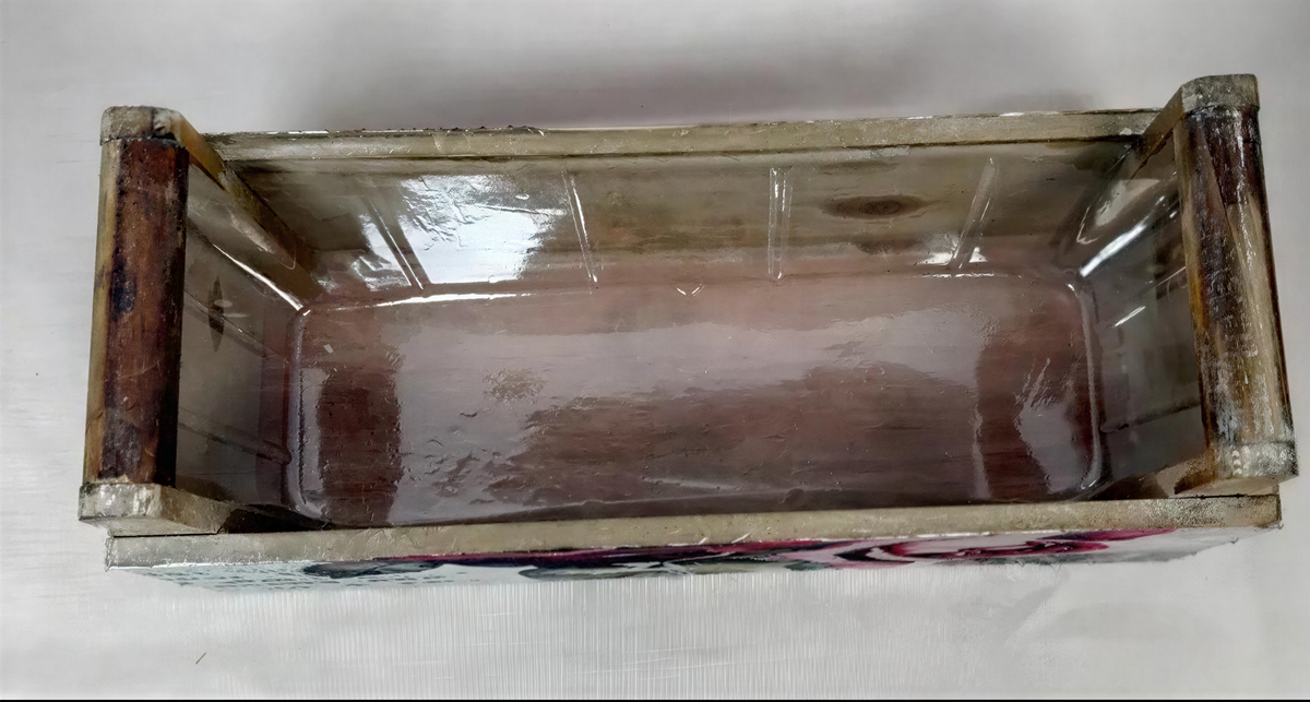 a wooden crate or box with a clear plastic window, sitting on a white surface.