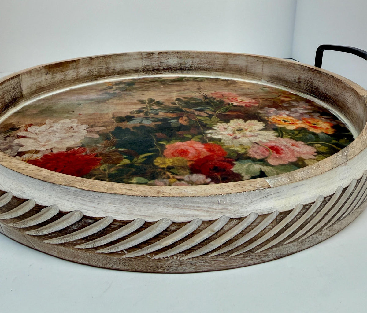 A wooden tray with a floral design on the surface, featuring a variety of colorful flowers and leaves.