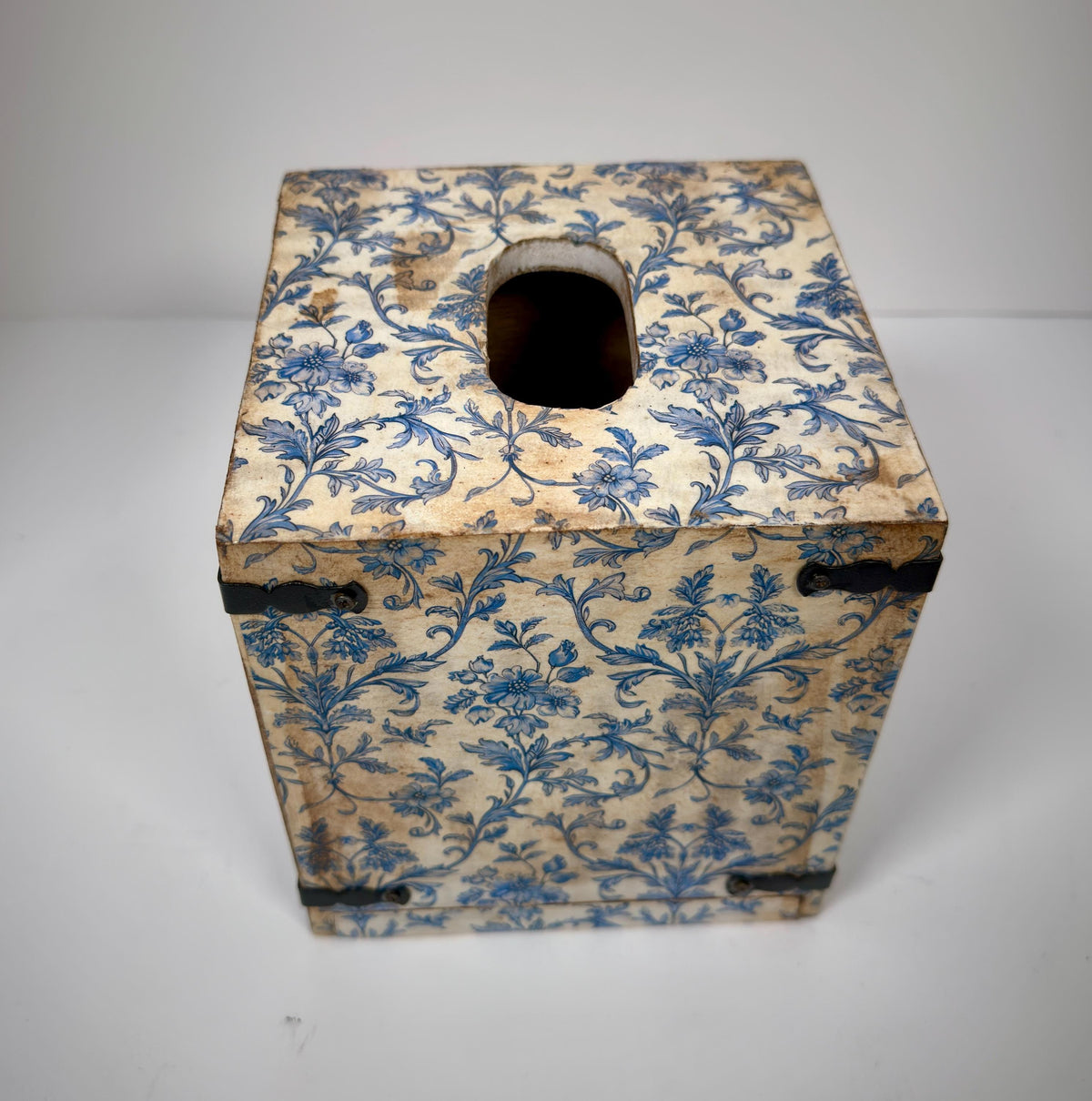 a wooden box with a blue floral pattern on its surface.