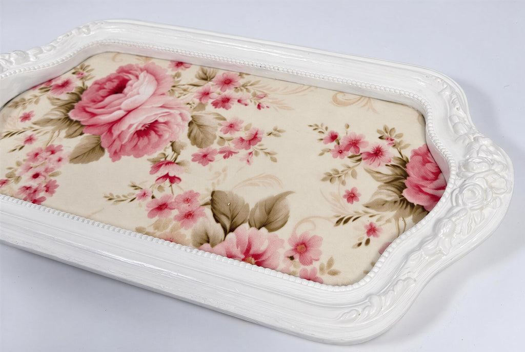 A white decorative tray with a floral pattern on it.