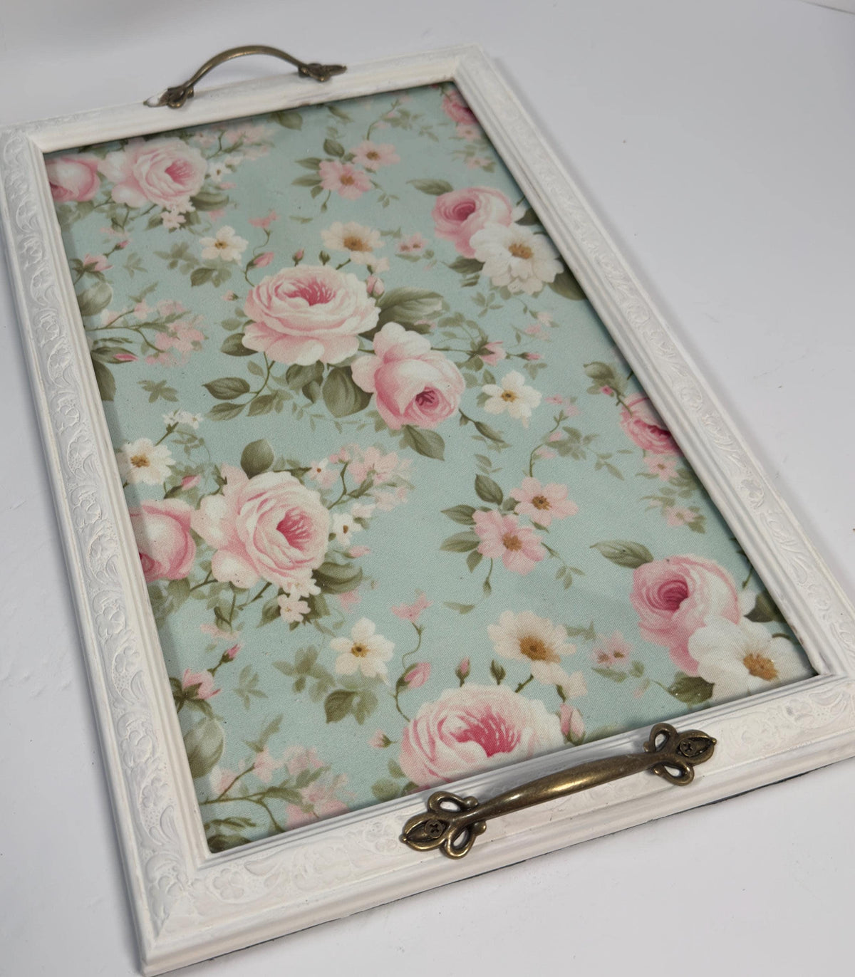 a white wooden frame with a floral pattern on the inside, which appears to be a decorative piece.