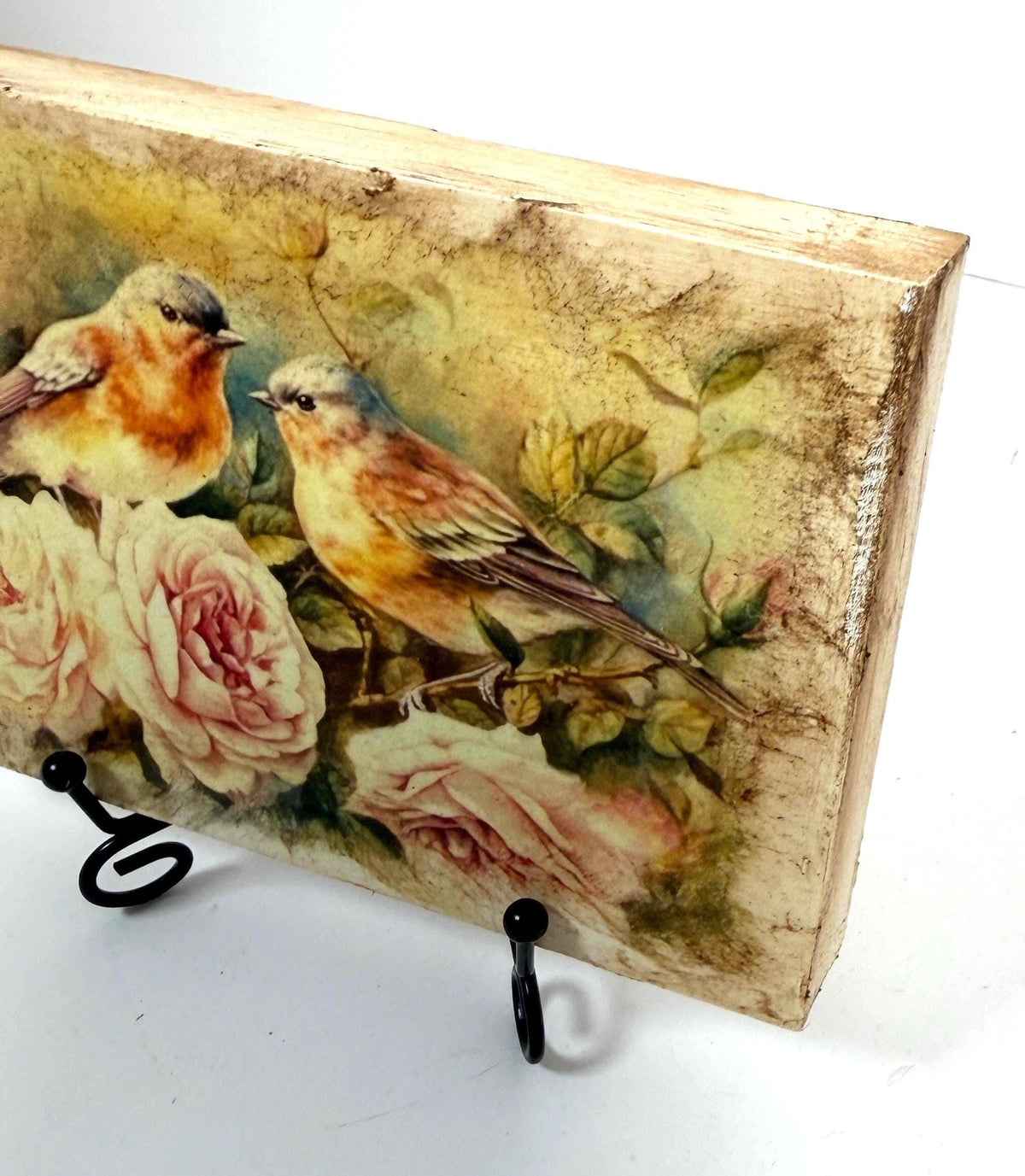 a painting of two birds perched on a branch with pink roses in the background.