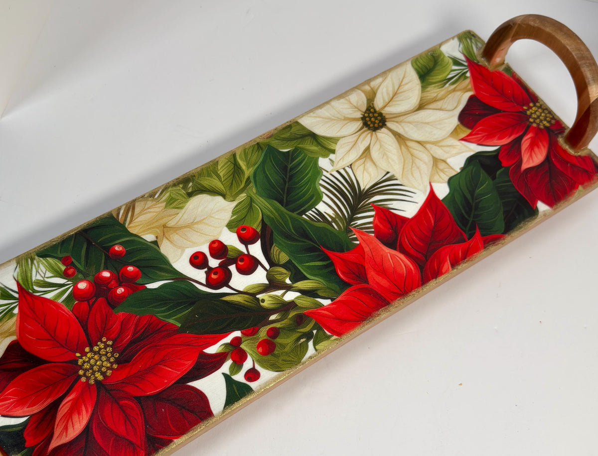 A decorative tray with a floral pattern featuring red poinsettia flowers, green leaves, and red berries.