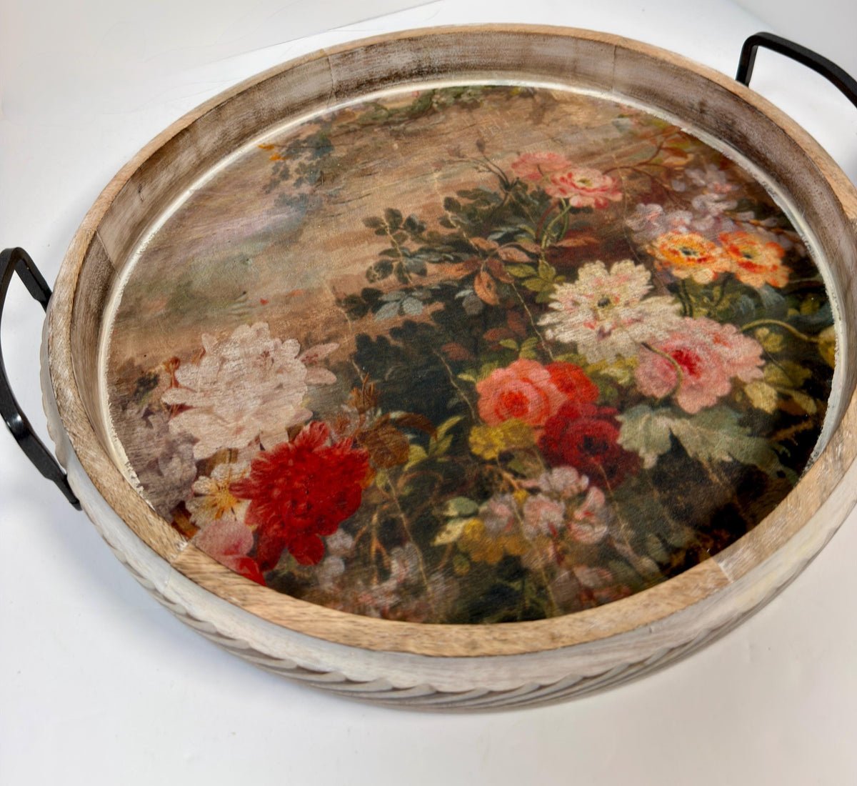 A wooden tray with a floral design on the surface, featuring a variety of colorful flowers and foliage.