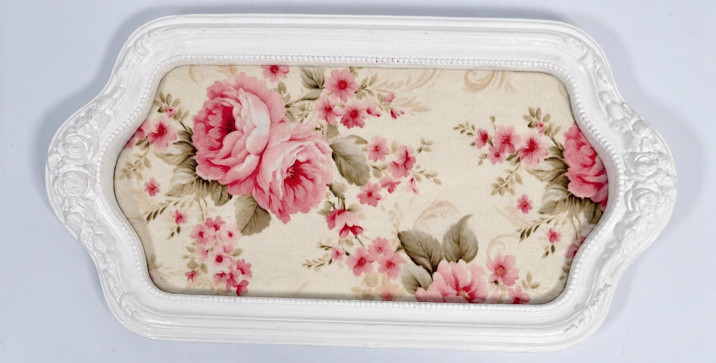 A white decorative tray with a floral pattern on the fabric covering it.