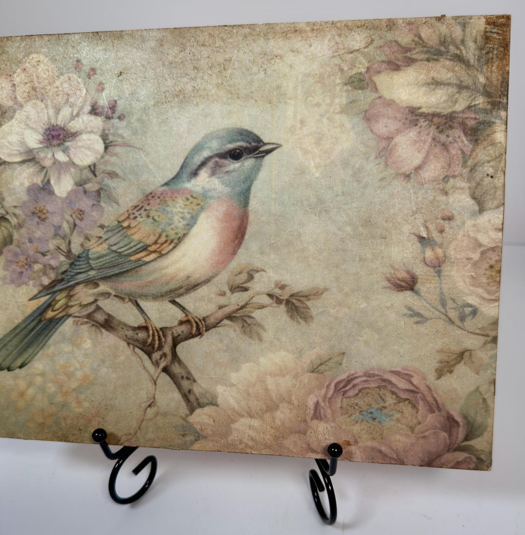 a vintage-style painting of a colorful bird perched on a branch, surrounded by flowers and foliage.