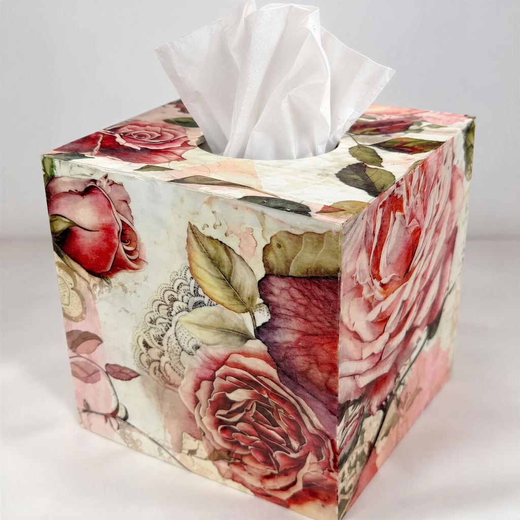 A decorative tissue box with a floral pattern, featuring a white tissue paper dispenser and a vibrant design of red and pink roses.