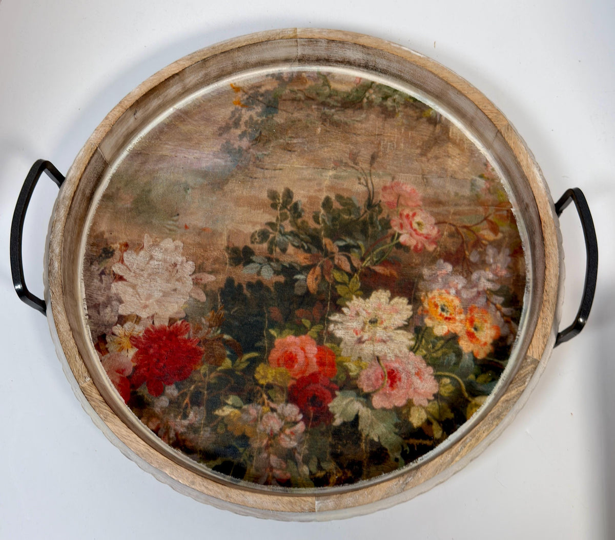 a round wooden tray with a floral design on it.