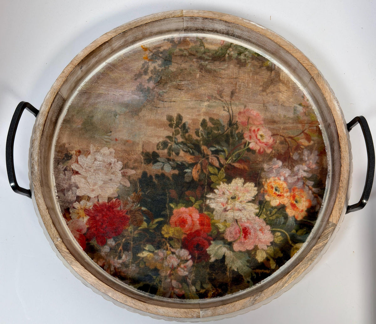 a round wooden tray with a floral painting on it.
