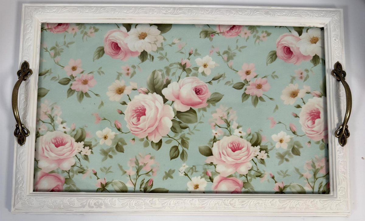 a white tray with a floral pattern of pink and white roses on a light blue background.
