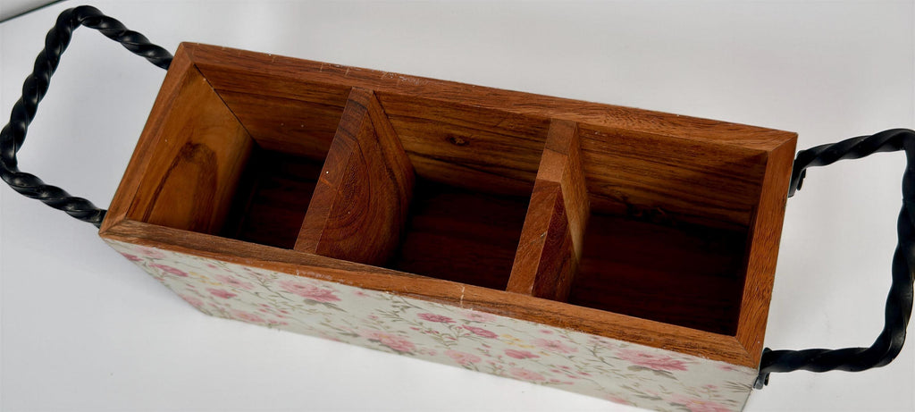 a wooden box with three compartments, each with a black metal handle. The box has a floral pattern on its exterior.