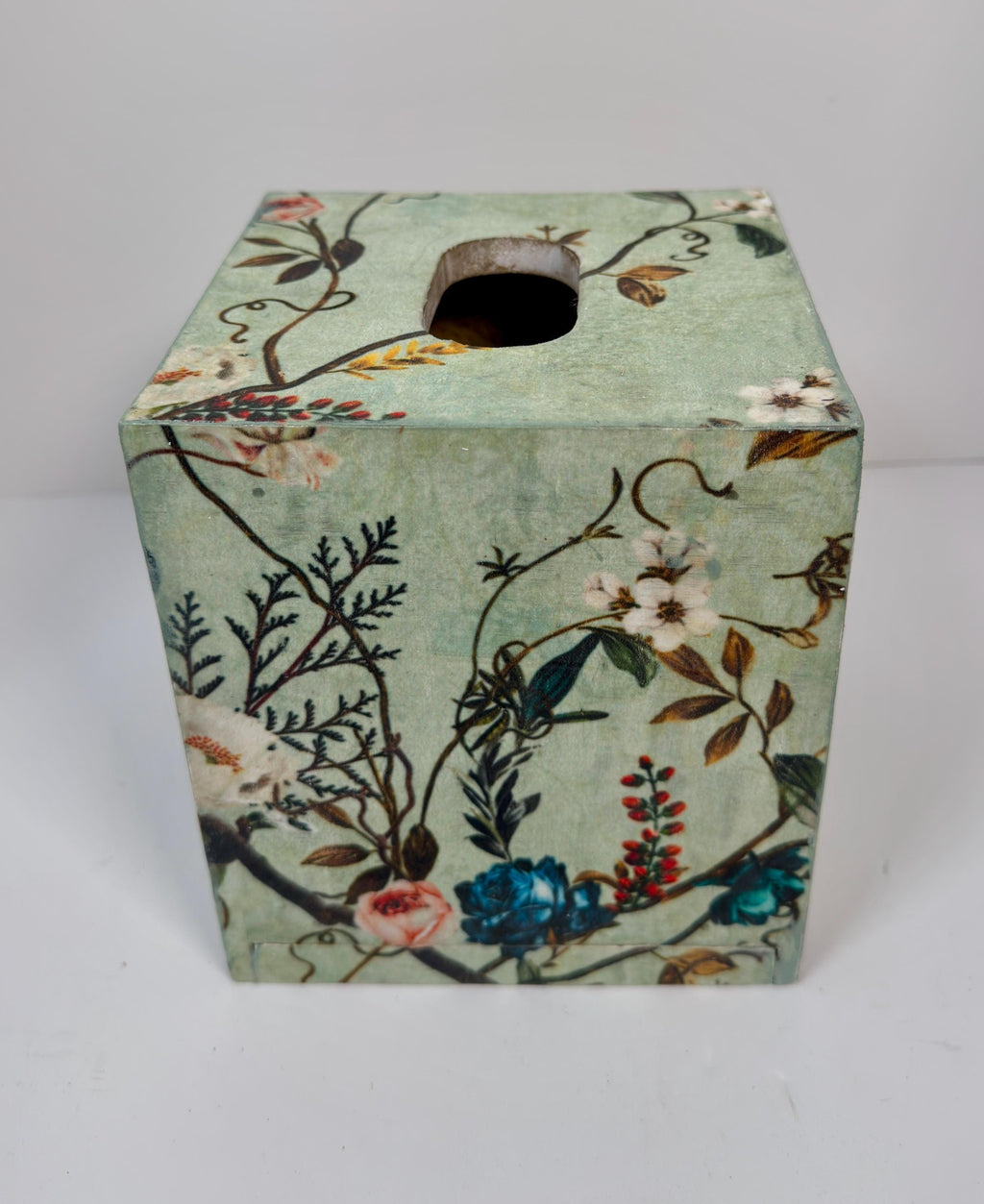 a square-shaped tissue box with a floral pattern on its surface.