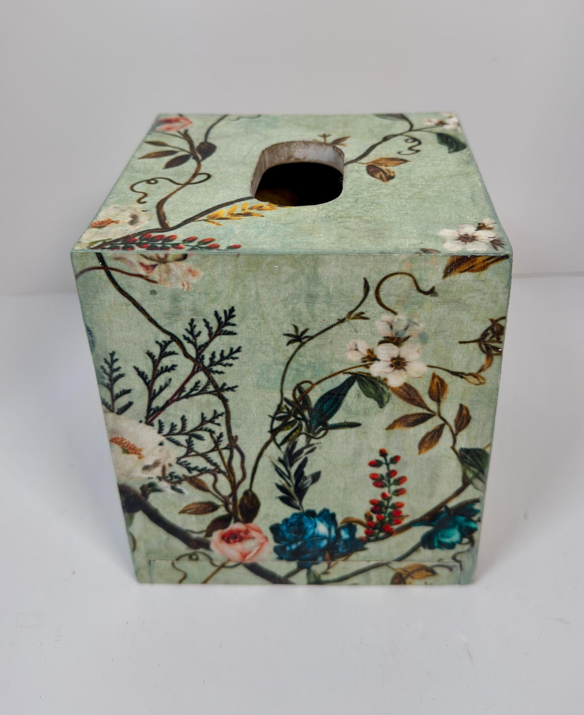 a square-shaped tissue box with a floral pattern on its surface.
