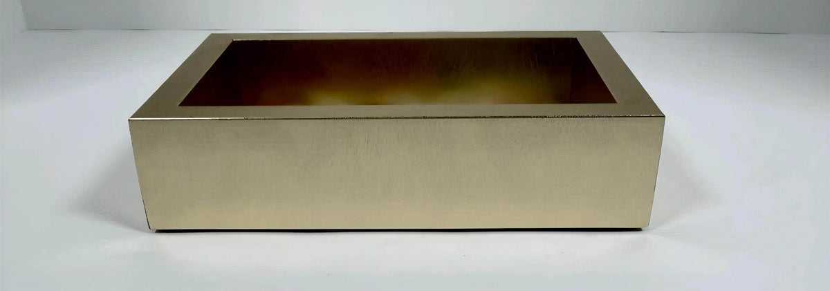 A gold-colored rectangular box with a visible interior, sitting on a white surface.
