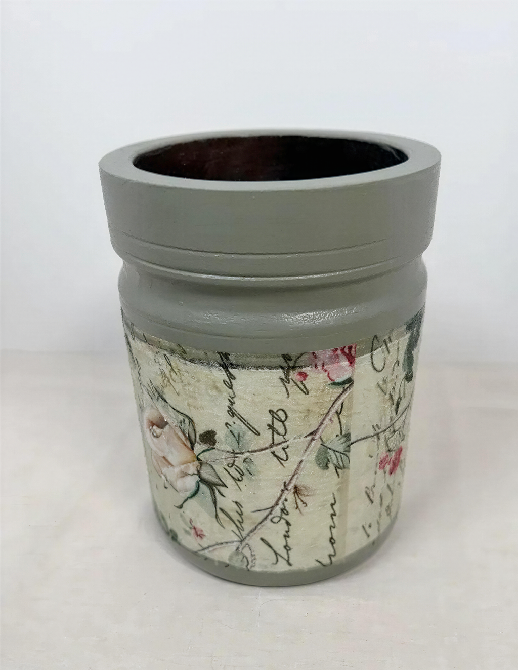 a gray vase with a floral pattern on it.