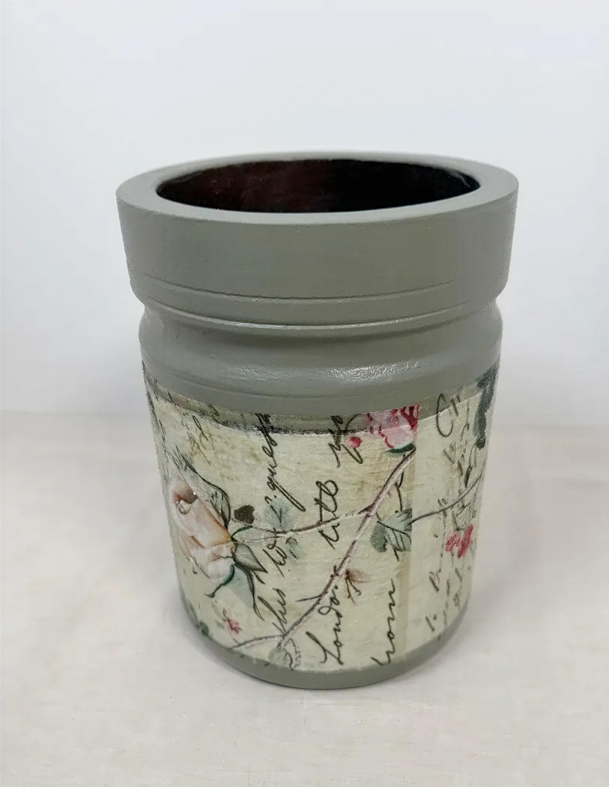 a gray vase with a floral pattern on it.