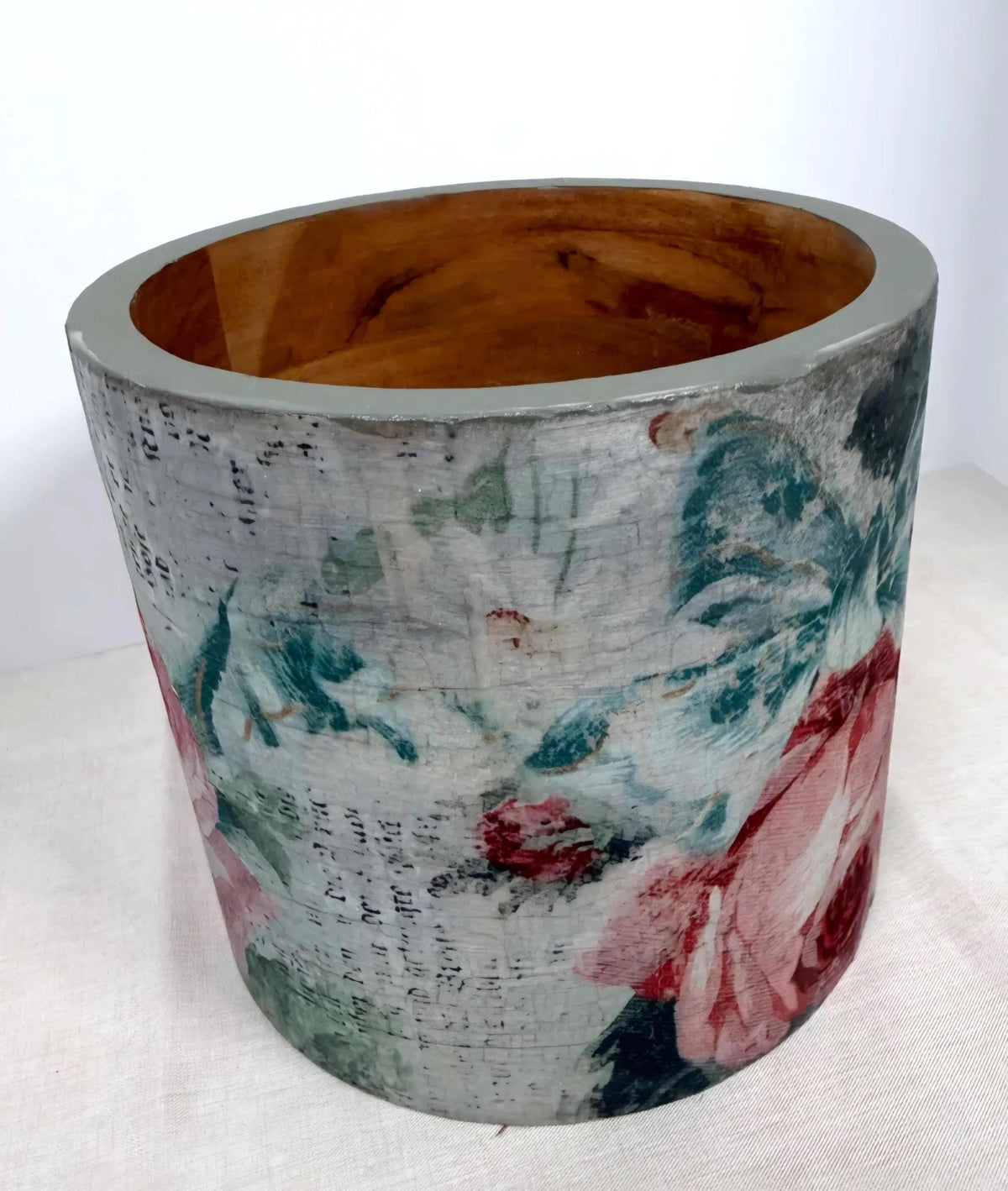 a cylindrical vase with a floral pattern on its surface.