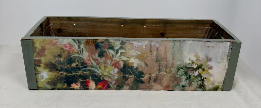 a wooden box with a floral pattern painted on it.