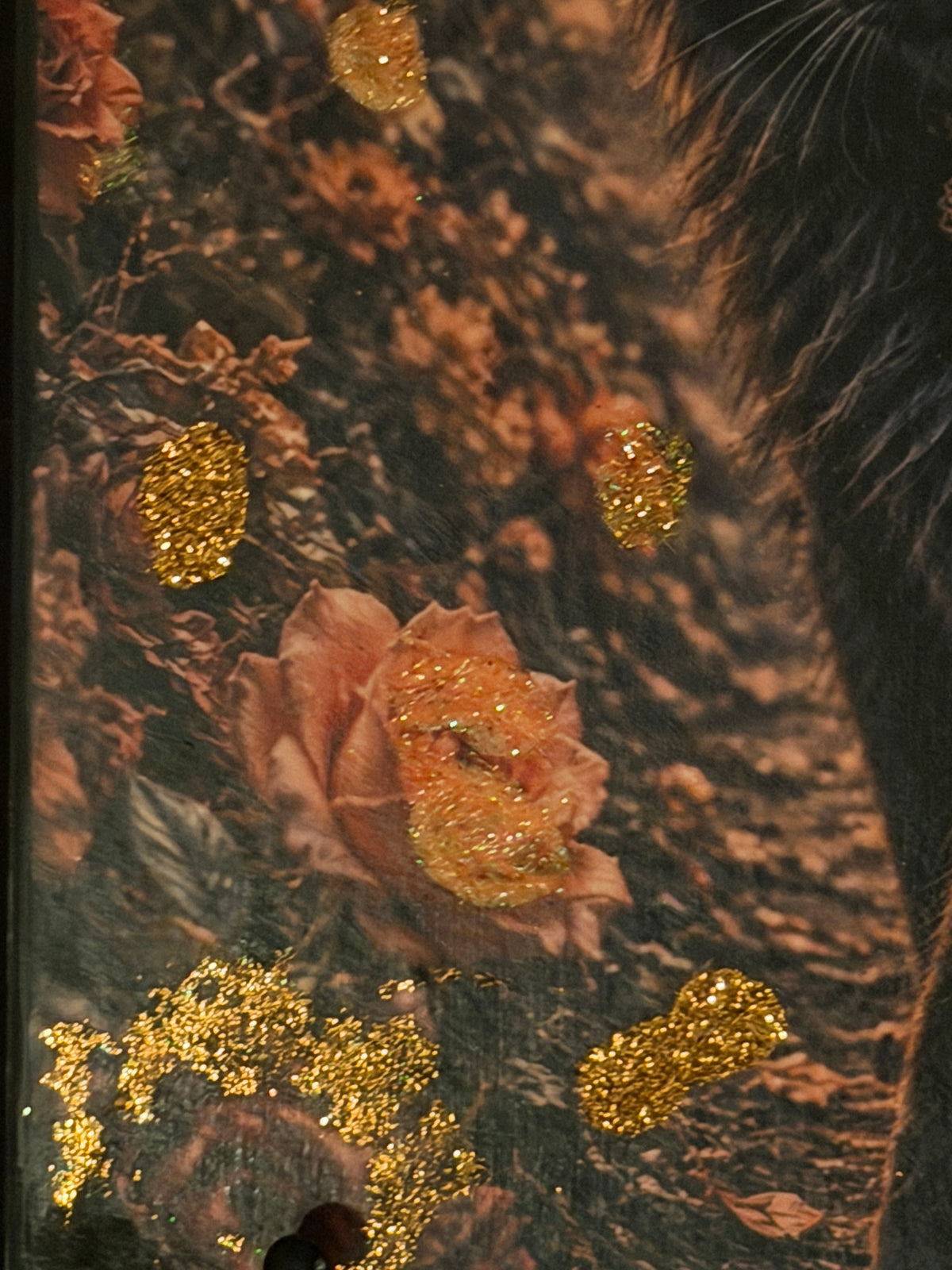 a close-up view of a vibrant pink rose with gold glitter accents, surrounded by other flowers and foliage.