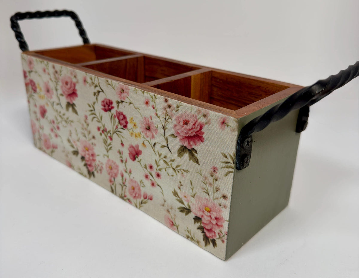 A wooden box with a floral pattern on its side, featuring three compartments.