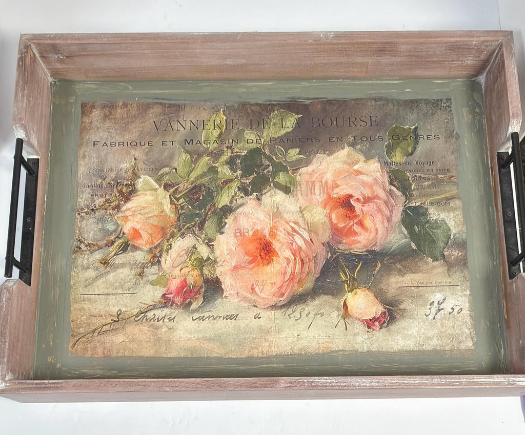 a wooden tray with a framed painting of three pink roses on it.