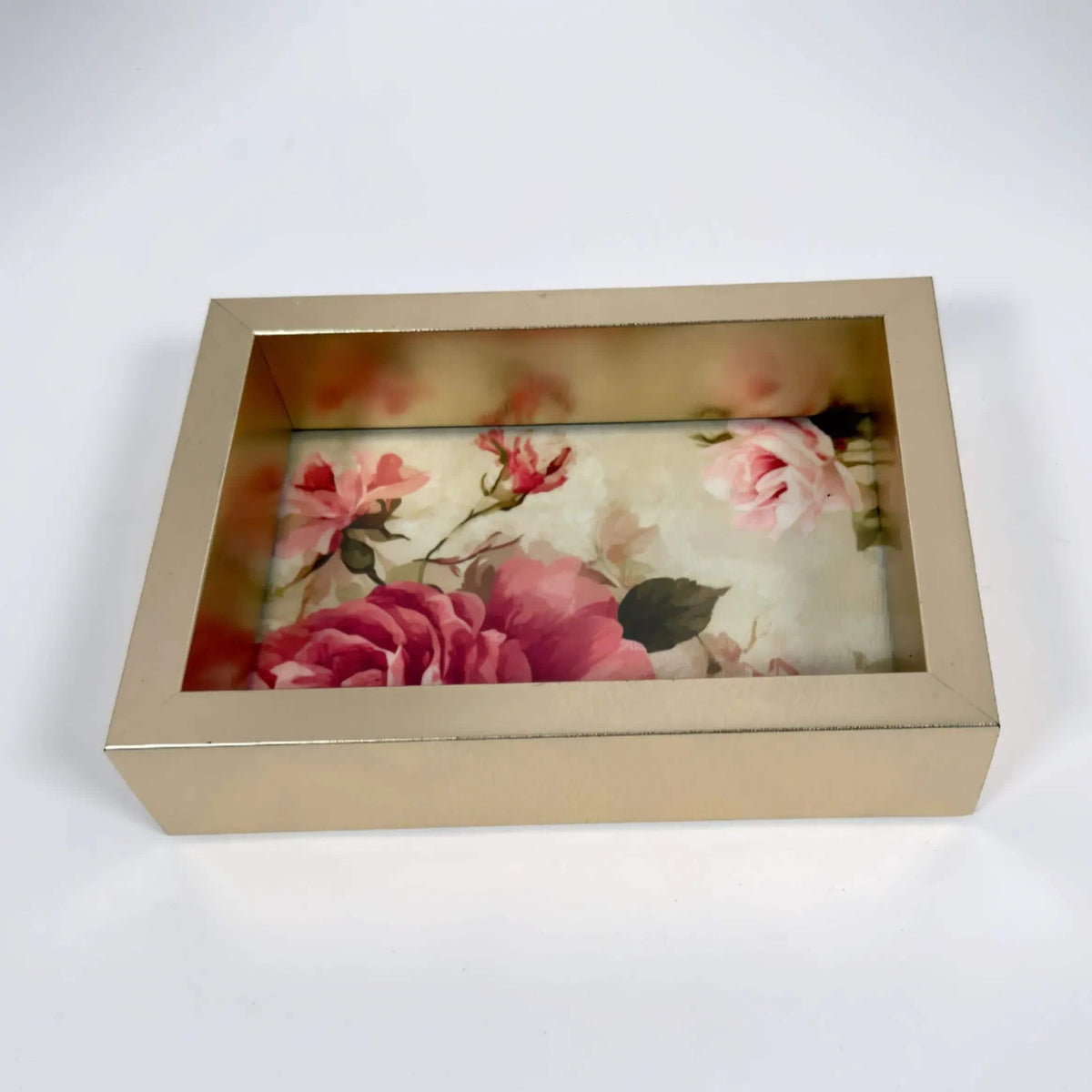 a gold-colored rectangular box with a floral design on the front, showcasing a variety of pink and red flowers.