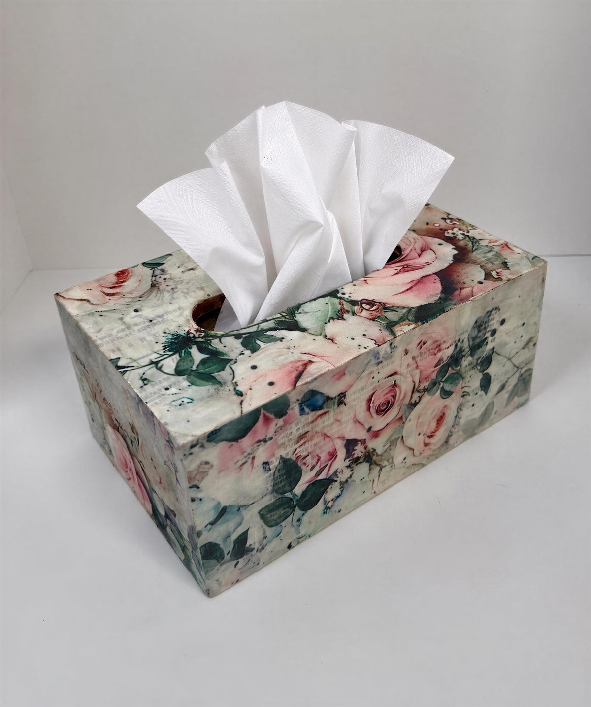 A floral-patterned tissue box with a white tissue paper dispenser inside.