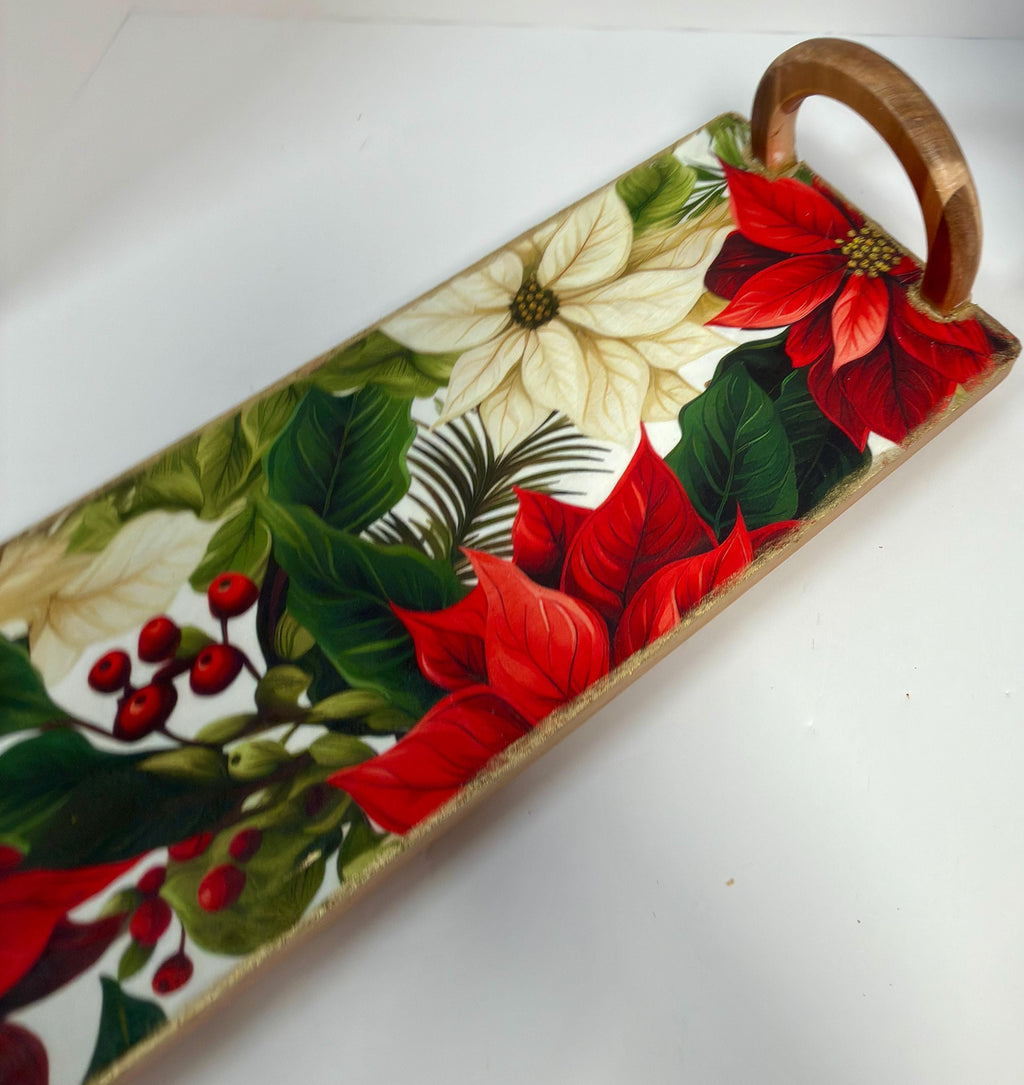 A decorative wooden tray with a floral pattern featuring red poinsettia flowers, green leaves, and red berries.