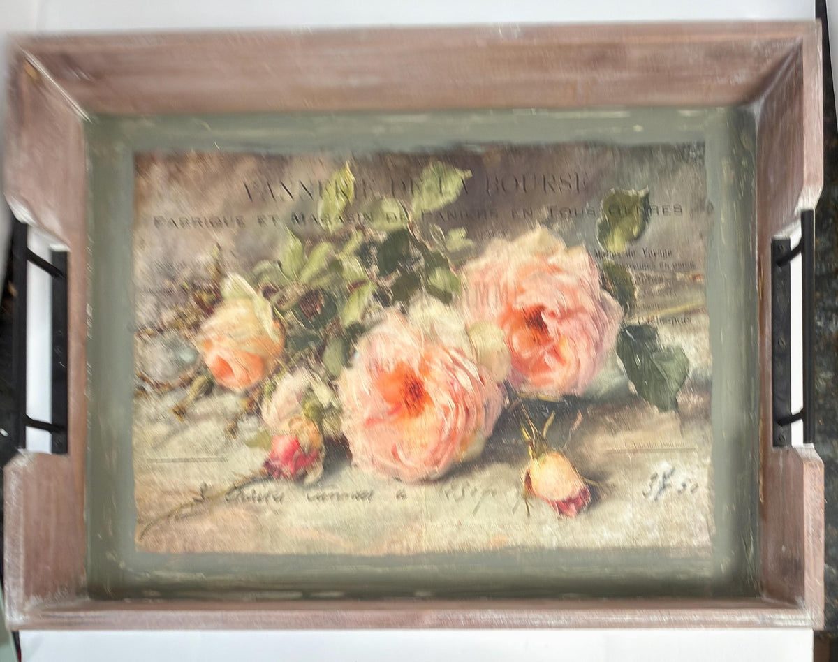 The image is a framed painting of three pink roses on a wooden tray.