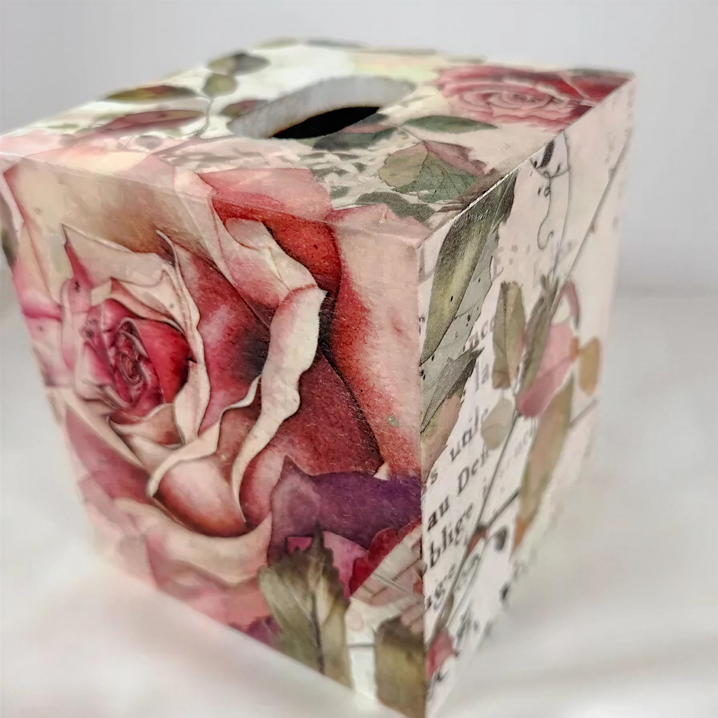 A decorative box cover with a floral pattern, featuring a large rose and other flowers in shades of pink and red.