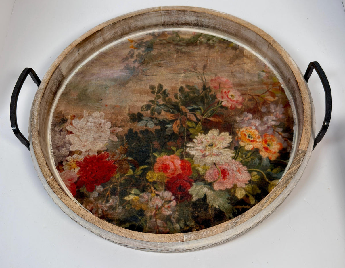 a round wooden tray with a floral design on it.