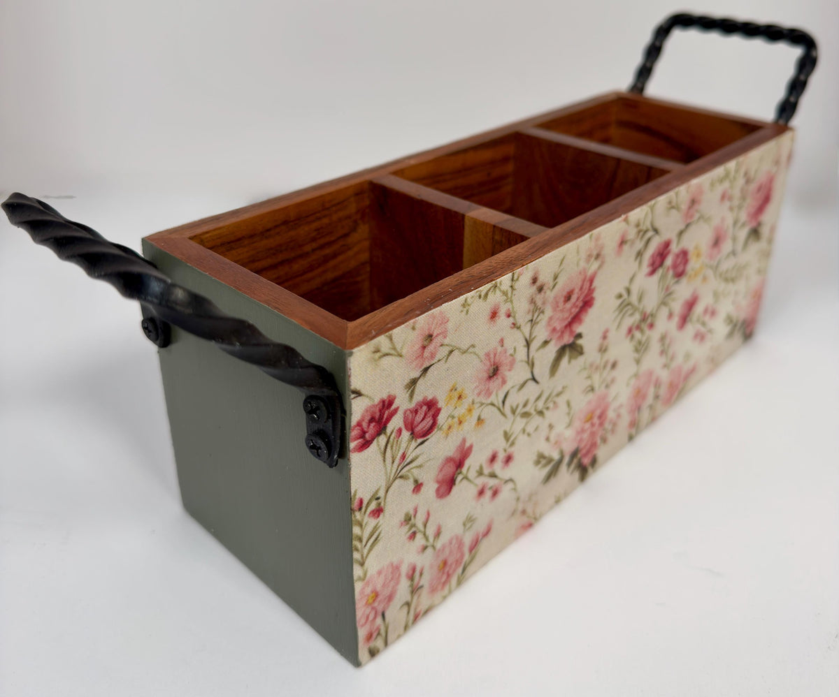 A wooden box with a floral pattern on the front, featuring three compartments.